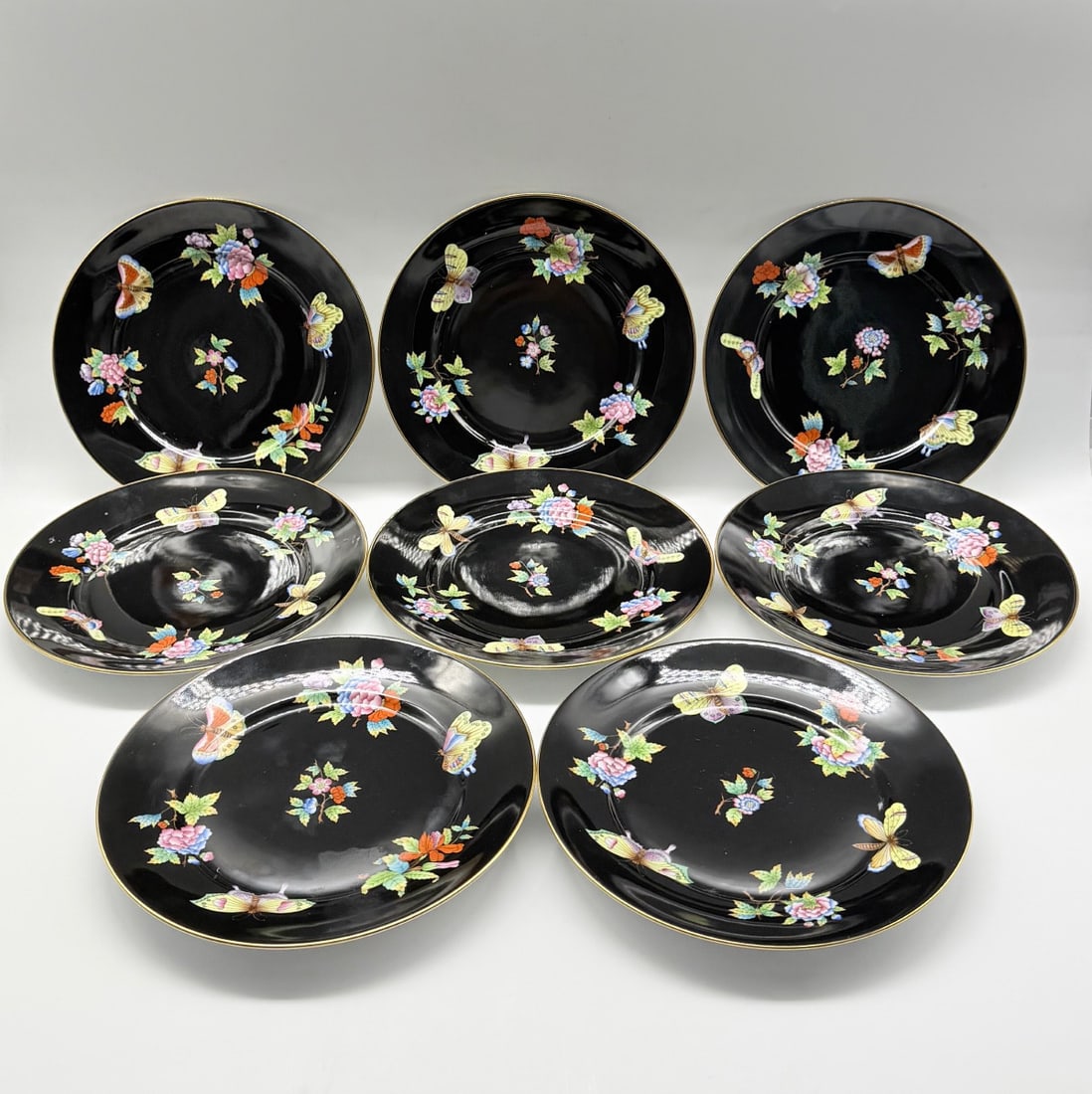 Herend porcelain plates Black Victoria or Butterfly Motif,set of 8: Highly delicate and incredibly rare set of Herend porcelain Black Victoria porcelain plates. Set of 8.Each plate finely hand painted with flowers and butterflies on the deep black background. Plates