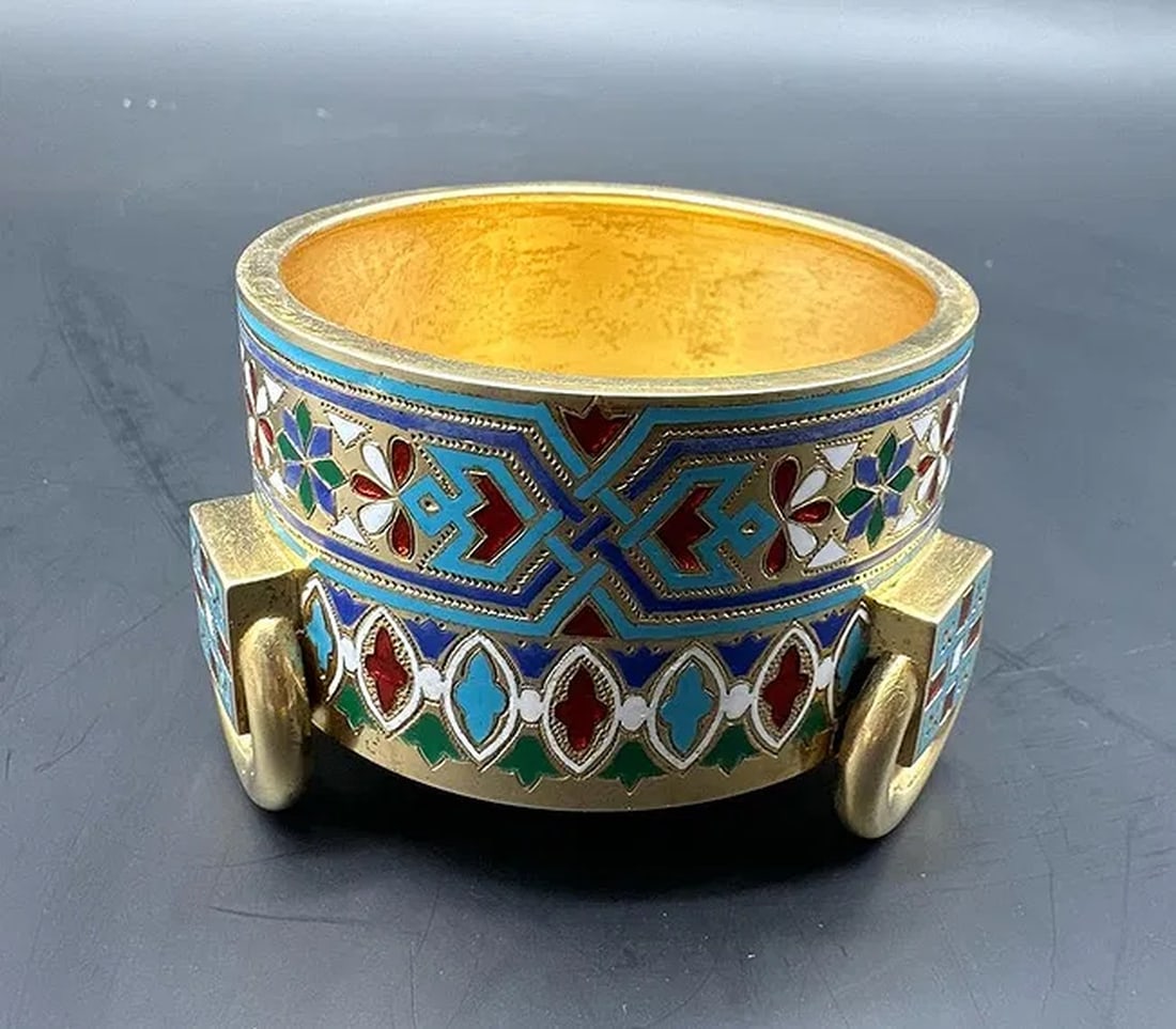 Ivan Khlebnikov, vermeil and champlevé enamel salt cellar, Russia, dated 1881.: Ivan KHLEBNIKOV (1819–1881)silver gilt (vermeil) and polychrome champlevé enamel salt cellar with a geometric neo-Russian style decoration, resting on three small cubic feet flanked by movable ring