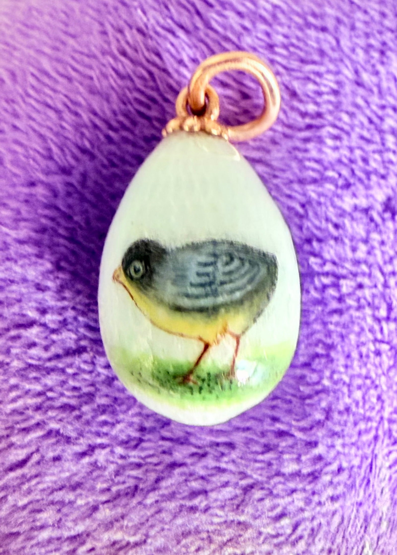 Fabergé | An Easter Egg Pendant in Gold and Guilloché Enamel, by Erik Kollin, St Petersburg,: Maison FABERGÉEaster egg pendant in 14K rose and yellow gold (56 zolotniks) with guilloché opalescent enamel, the body decorated with a polychrome miniature enamel painting of a young chick on a bla