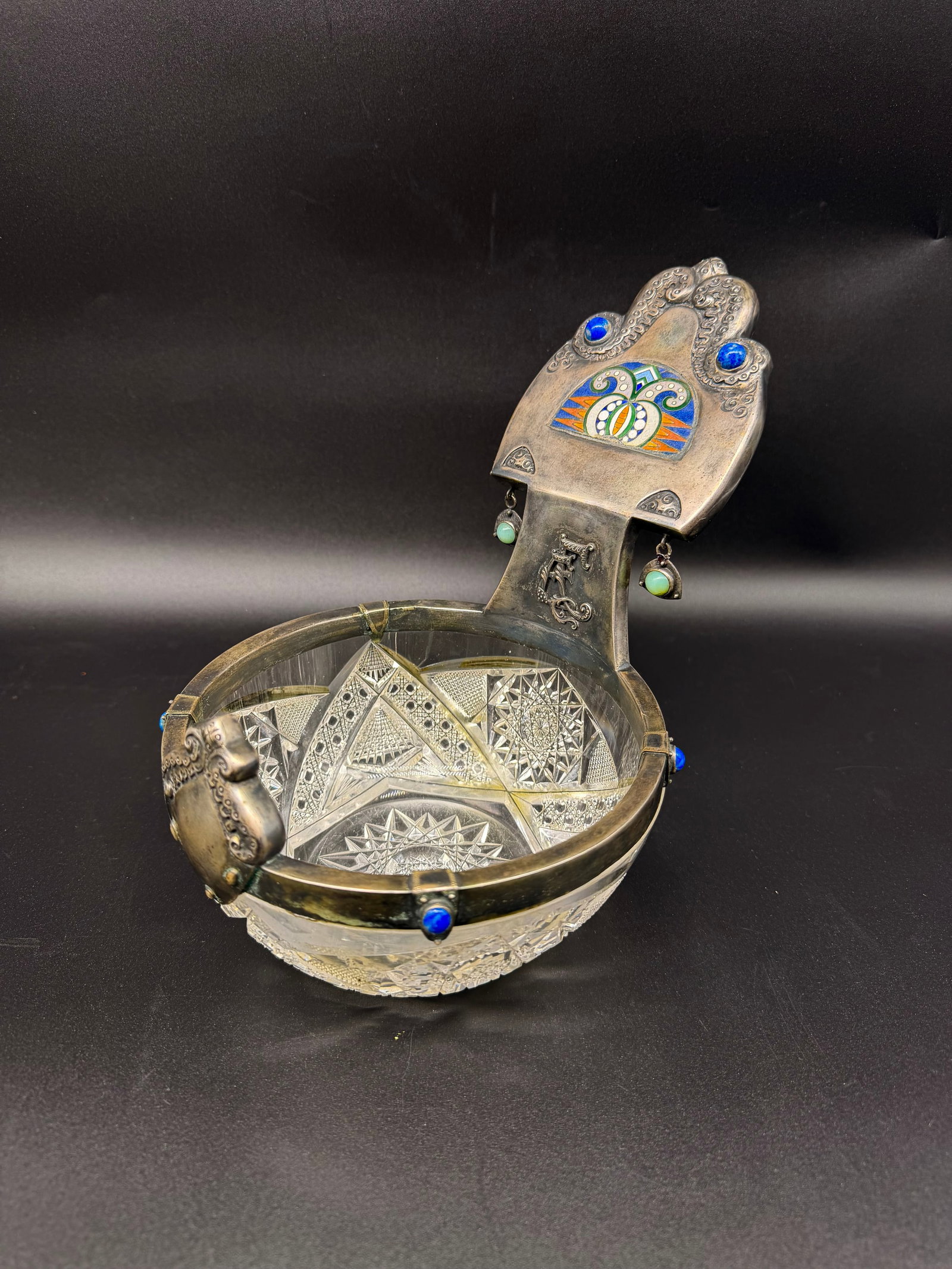 Orest Kurlyukov (1845–1916) | A Russian Rock Crystal and Silver-Gilt Cloisonné Enamel Kovsh,: Orest Fedorovich Kurlyukov (1845–1916)Traditional kovsh in geometric cut crystal with silver mount decorated with polychrome cloisonné enamel of stylised floral motifs, set with hardstone cabochons