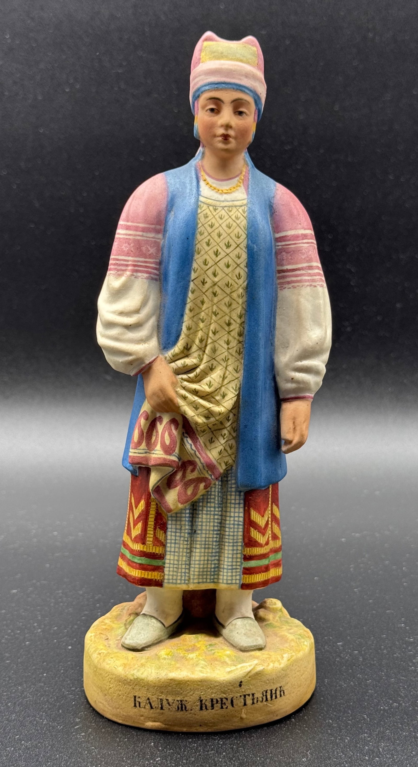 Gardner Manufactory, “Peasant Woman of Kaluga?? porcelain figure from the Peoples of Russia: Statuette representing a “Peasant Woman of Kaluga” (?????. ?????????) from the famous Peoples of Russia series, in tinted porcelain and biscuit painted in polychromy. The young woman stands on