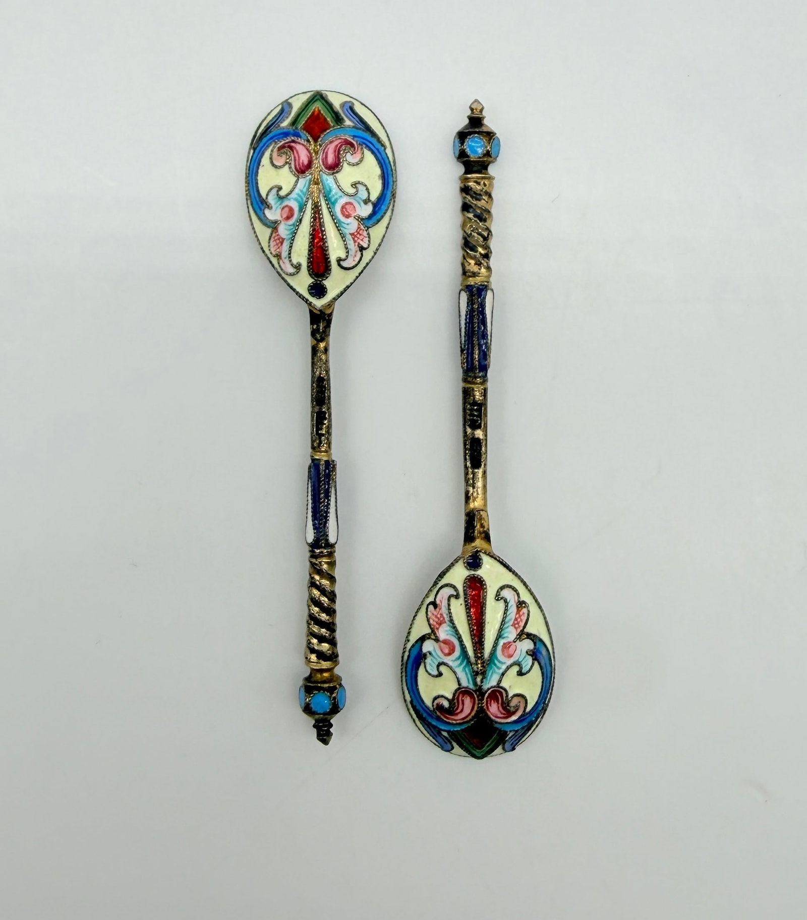 Gustav Klingert, a Pair of Gilt-Silver and Cloisonné Enamel Mocha Spoons, Moscow, 1898–1908p0p: Pair of small salt or mocha spoons in silver-gilt and cloisonné enamel.The reverse of the pear-shaped spoon bowls is richly decorated with stylised polychrome floral and foliate motifs in red, pink, 