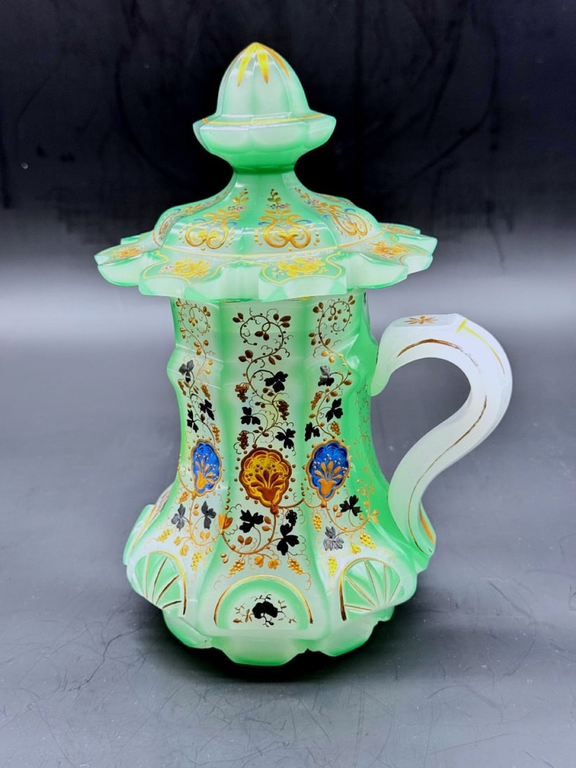 BOHEMIAN MINT-GREEN OPALINE 'BARFATAN' COVERED TANKARD, 19TH CENTURY: An extraordinary covered tankard (barfatan) crafted in opaque light mint-green opaline glass, featuring a faceted, lobed body with an integrated loop handle and a domed cover topped by a pointed bud f