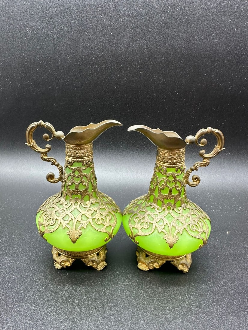 A PAIR OF FRENCH GILT-BRONZE MOUNTED GREEN URANIUM OPALINE GLASS JUGS, PALAIS-ROYAL, NAPOLEON III: Pair of small ewer-shaped jugs crafted in translucent apple-green uranium opaline glass. Each piece features a bulbous body and a tapering neck encased within elaborate openwork gilt-bronze (ormolu) m