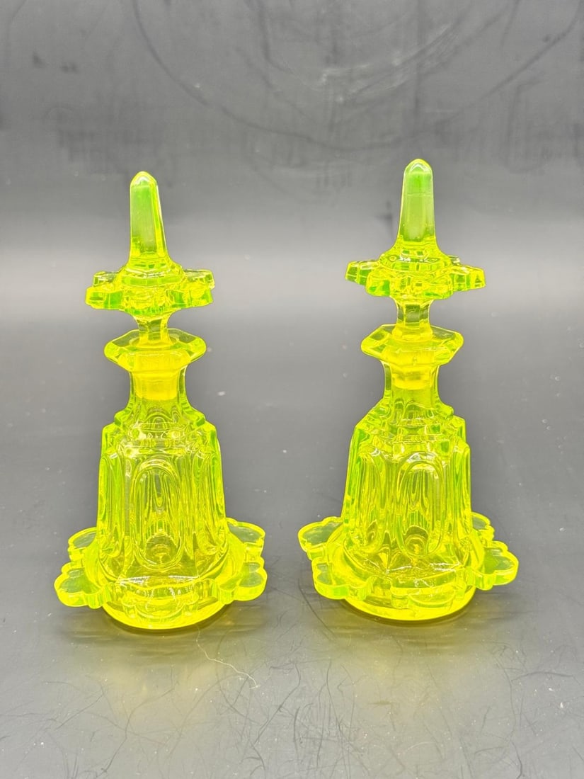 PAIR OF BOHEMIAN PRESS-CUT URANIUM GLASS PERFUME BOTTLES, LATE 19TH CENTURY: A striking pair of vanity perfume bottles (flacons à parfum) crafted in vibrant yellow-green uranium glass (Annagelb/Annagrün). Each bottle features a paneled, bell-shaped body with molded arch moti