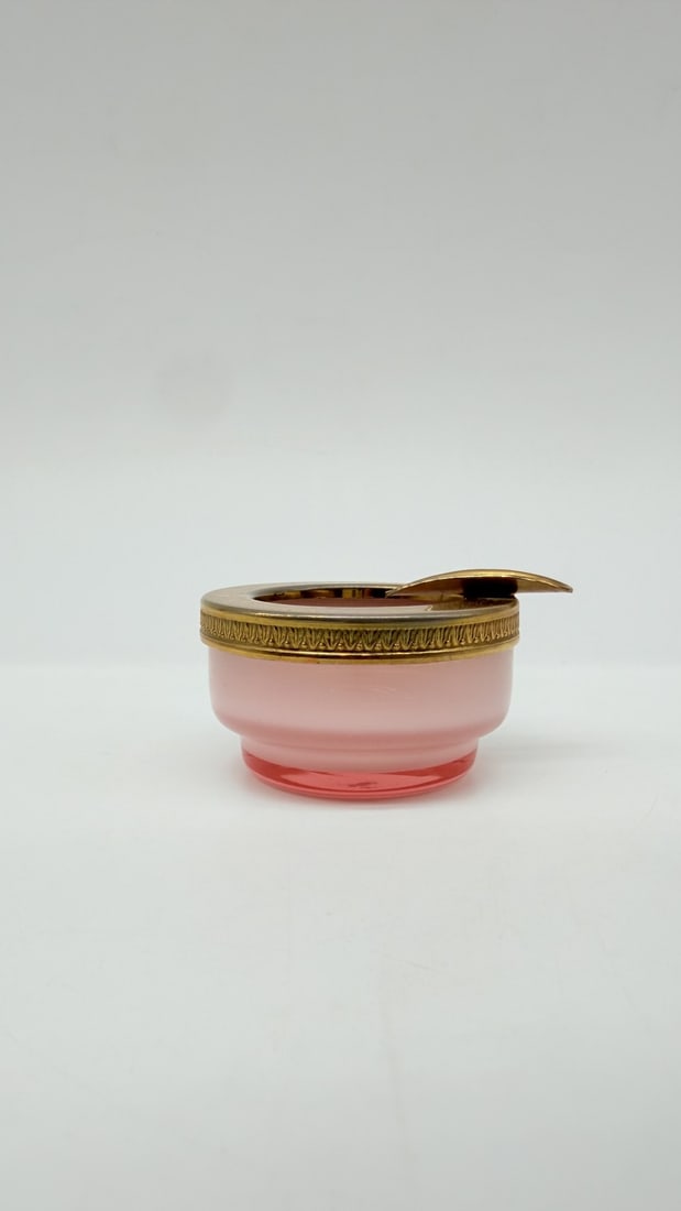 MURANO PINK OPALINE OVERLAY GLASS ASHTRAY WITH BRASS MOUNT, MID-20TH CENTURY: A small circular ashtray crafted in pink overlay opaline glass. The vessel features a dual-layer structure with a soft pink opaline exterior casing over a darker rose-pink glass base. The upper rim is