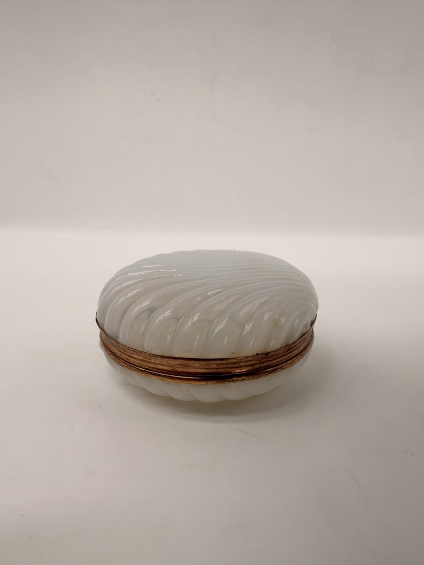 MILK WHITE OPALINE GLASS BOX WITH GILT-BRONZE MOUNT, CHARLES X PERIOD, CIRCA 1820–1830: A small circular trinket box crafted in milk-white opaline glass featuring a translucent soap-bubble appearance. The cover and base are cut in a raised chessboard diamond-point pattern. The two halves