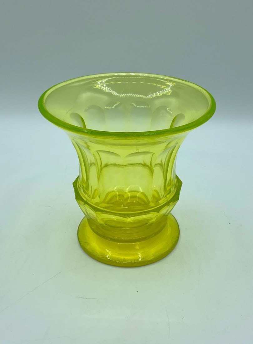 BIEDERMEIER URANIUM GLASS VASE, 19TH CENTURY: An antique Biedermeier yellow-green uranium glass (Annagrün) vase with a wide flared rim and a circular pedestal foot. The thick-walled body features broad vertical facets and arched thumbprint (Kuge