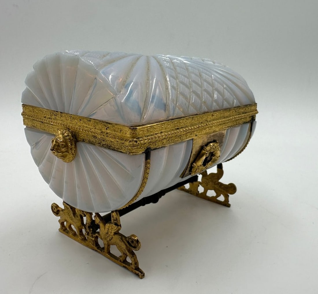 FRENCH "BULLE DE SAVON" OPALINE GLASS AND GILT-BRONZE MOUNTED CASKET, FIRST EMPIRE PERIOD, CIRCA: Opaline glass casket in iridescent, semi-translucent "soap bubble" opaline crystal. The body and domed cover are wheel-cut with bold bamboo-style ribs and a central diamond-cut lattice pattern, flanke