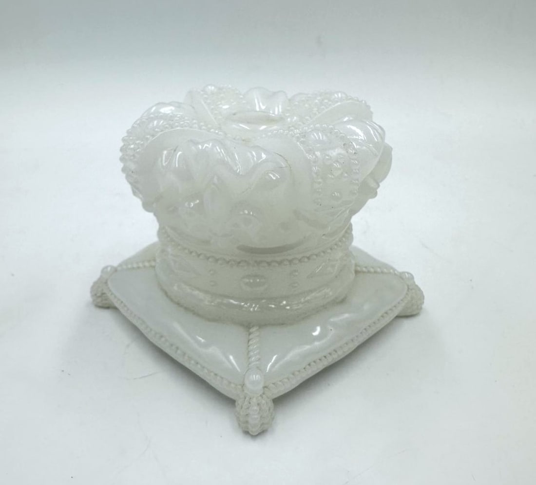 CROWN-SHAPED OPALINE GLASS COVERED BOX ON CUSHION, LATE 19TH CENTURY: White opaline glass box in the form of a royal crown resting upon a square cushion. The cover is sculpted as an elaborate, beaded imperial crown with arched bands, while the base forms a cushioned ped