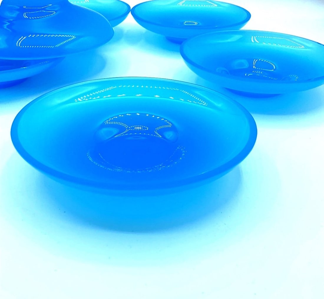 SET OF SIX ITALIAN TURQUOISE BLUE OPALINE GLASS SMALL DISHES, MURANO, LATE 20TH CENTURY: A set of six small circular dishes in translucent turquoise blue opaline glass. Each dish features a smooth, shallow circular bowl form with a slightly raised rim and a defined central recess.Italy (M