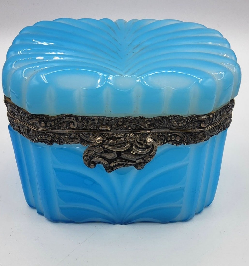 BOHEMIAN BLUE OPALINE GLASS CASKET WITH AUSTRIAN SILVER MOUNTS, DATED 1849: A rectangular glass casket in light blue opaline glass (Barfatan style). The hinged cover and body feature deeply molded, curved fluting in a shell-and-feather pattern. The casket is mounted with an c