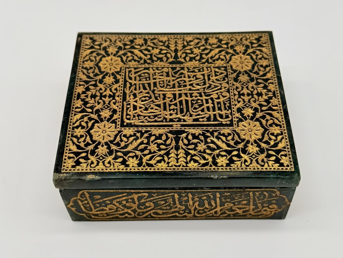 INDO-PERSIAN ENGRAVED AND GILDED GREEN JASPER LIDDED CASKET BOX, 19TH CENTURY: A rectangular lidded box crafted from deep green jasper stone showing natural veining. The flat lid features a central rectangular epigraphic panel with stylized Thuluth script, reading: "O Prophet, W