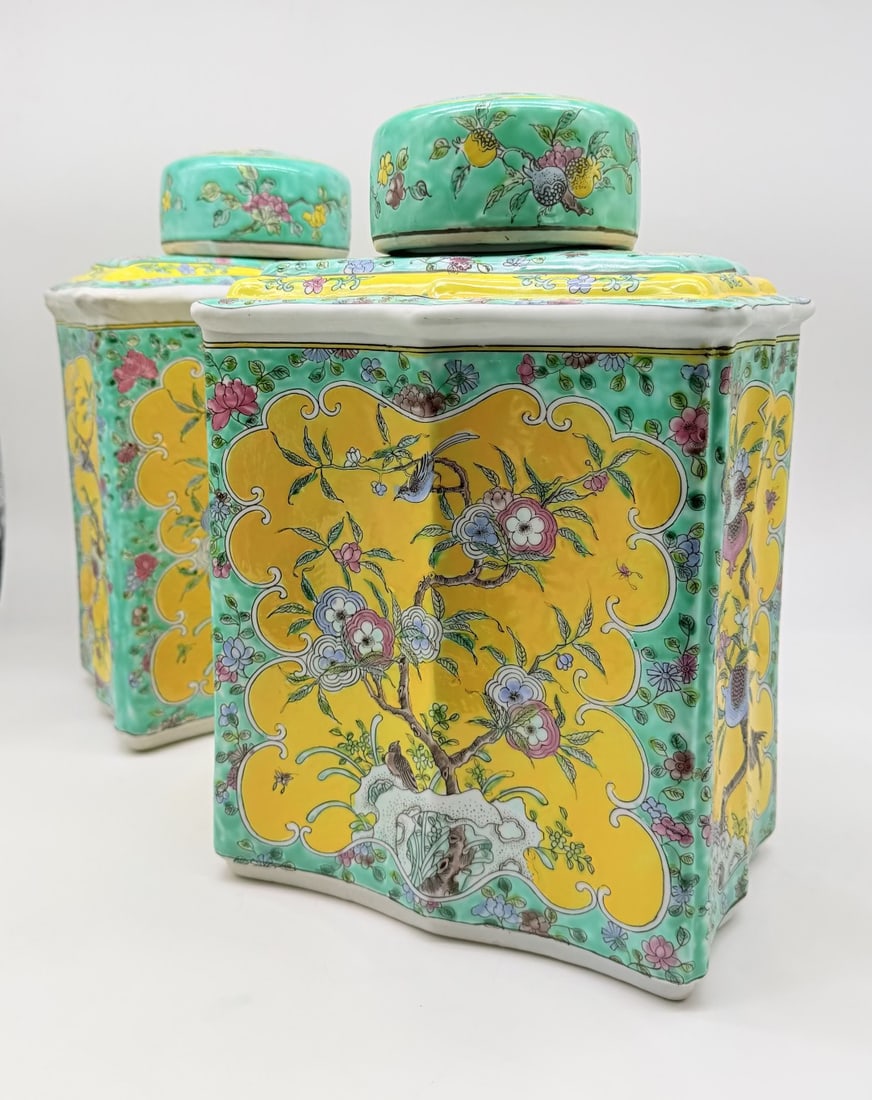 PAIR OF COVERED FAMILLE JAUNE PORCELAIN VASES, CHINA, APOCRYPHAL KANGXI MARK: A pair of large, lidded, quadrangular porcelain vases in the ‘Yellow Family’ style, decorated with polychrome enamel depictions of birds perched on perforated rocks and branches of plum trees and 