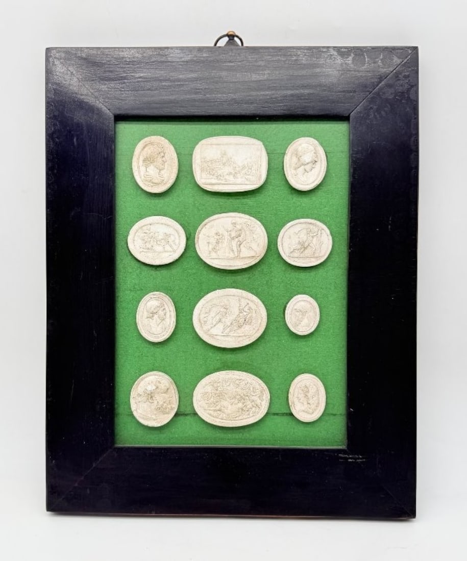 Set Of Twelve Plaster Intaglio Impressions, Italy, 19th Century: A set of twelve plaster casts of intaglio engravings depicting mythological subjects and classical profiles, set in a rectangular blackened wooden frame against a green felt background.Italy. 19th cen