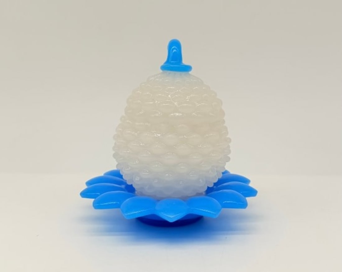 Pineapple-form Opaline Covered Jar, Baccarat: A pineapple-shaped box in white and blue opaline glass, the body decorated with raised dots, the lid topped with a curved stem-shaped handle, and the flared base forming a corolla of leaves.France, Ba