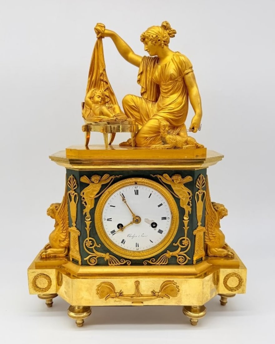 Empire Gilt-bronze Mantel Clock “fidelity??, Circa 1810–1820: A significant mantel clock known as ‘à la Fidélité’ or ‘La jeune mère’, in chiselled bronze, gilded with both matt and glossy gold, and featuring a sheet metal panel painted in Empire gree