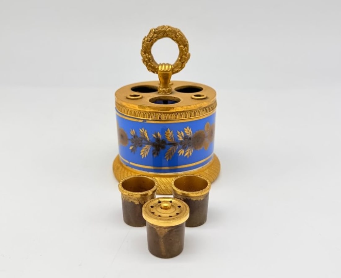 Cobalt Blue Opaline And Gilt Bronze Inkstand, France, Circa 1830: A cylindrical desk inkwell in cobalt-blue opaline, decorated with a gold-enamelled frieze of garlands of flowers and leafy branches, topped by a chiselled and gilded bronze mount with a gadrooned desi