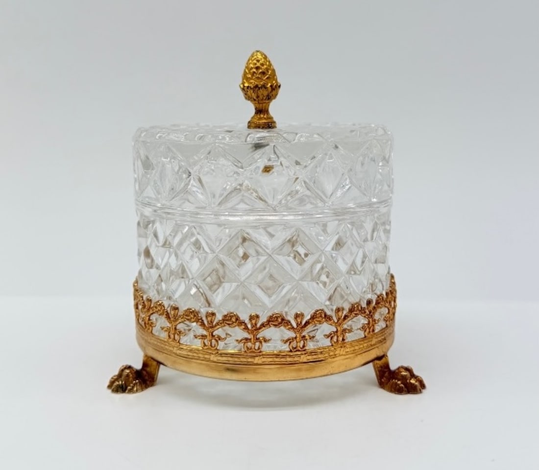 FRENCH CUT-CRYSTAL COVERED BOX WITH GILT-BRONZE MOUNTS, CHARLES X PERIOD: A round covered jewelry box in clear lead crystal, deeply cut with a diamond-point geometric pattern. The box rests within an openwork gilt-bronze (ormolu) collar gallery decorated with stylized flora