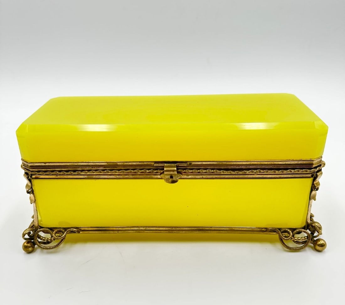 FRENCH CANARY-YELLOW OPALINE GLASS AND GILT-BRONZE CASKET, CHARLES X PERIOD: A large rectangular casket crafted from vibrant canary-yellow opaline glass with bevel-cut edges on the lid. The box is set within a gilt-bronze (ormolu) hinged rim mount with a central thumbpiece, su