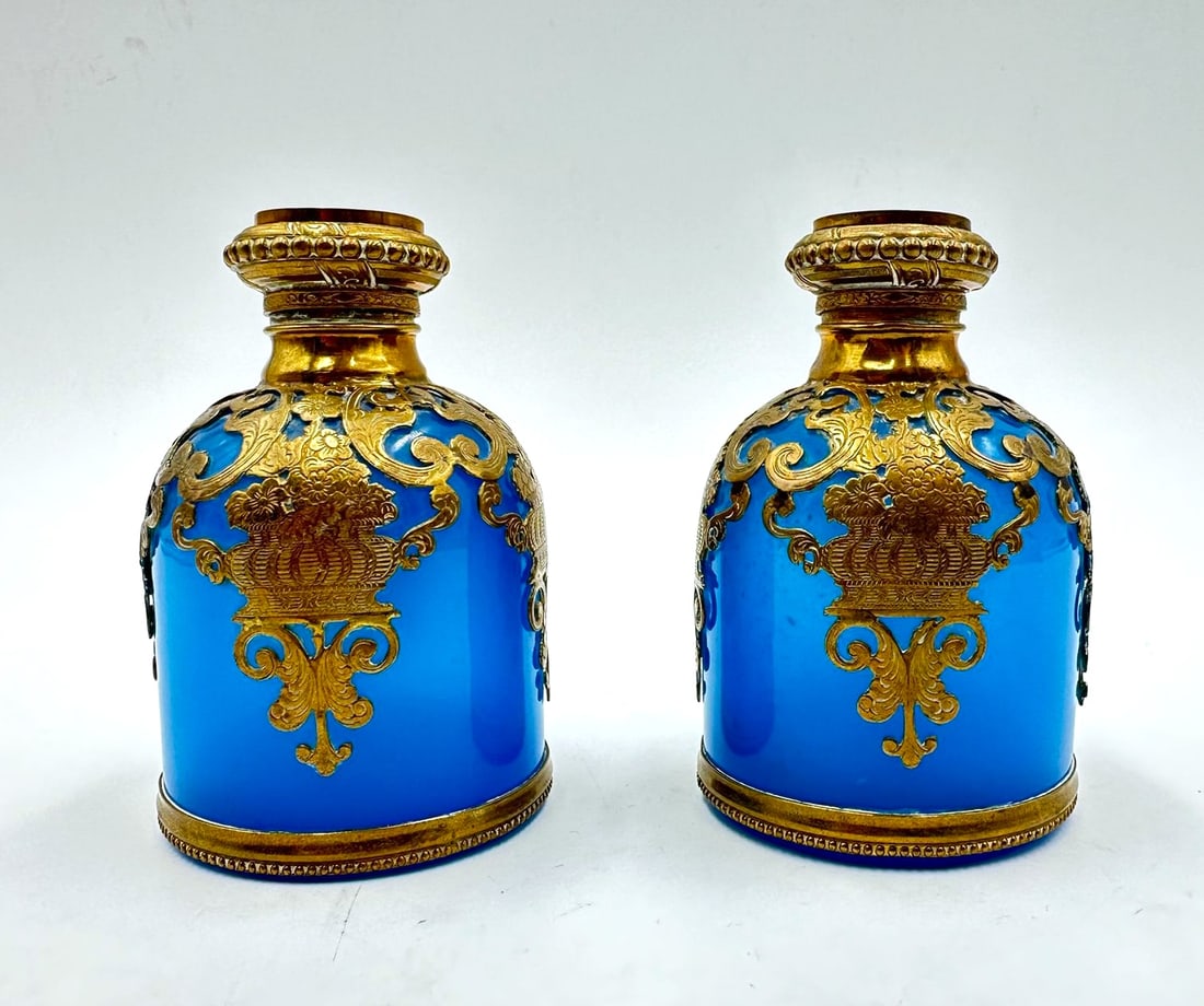 PAIR OF FRENCH TURQUOISE OPALINE PERFUME BOTTLES WITH MINIATURE VIEWS, PALAIS ROYAL, CHARLES X: Pair of French turquoise-blue opaline glass perfume bottles, encased in delicate openwork and chased gilt-brass (ormolu) mounts featuring scrolling foliate, basket, and floral scroll motifs. The hinge