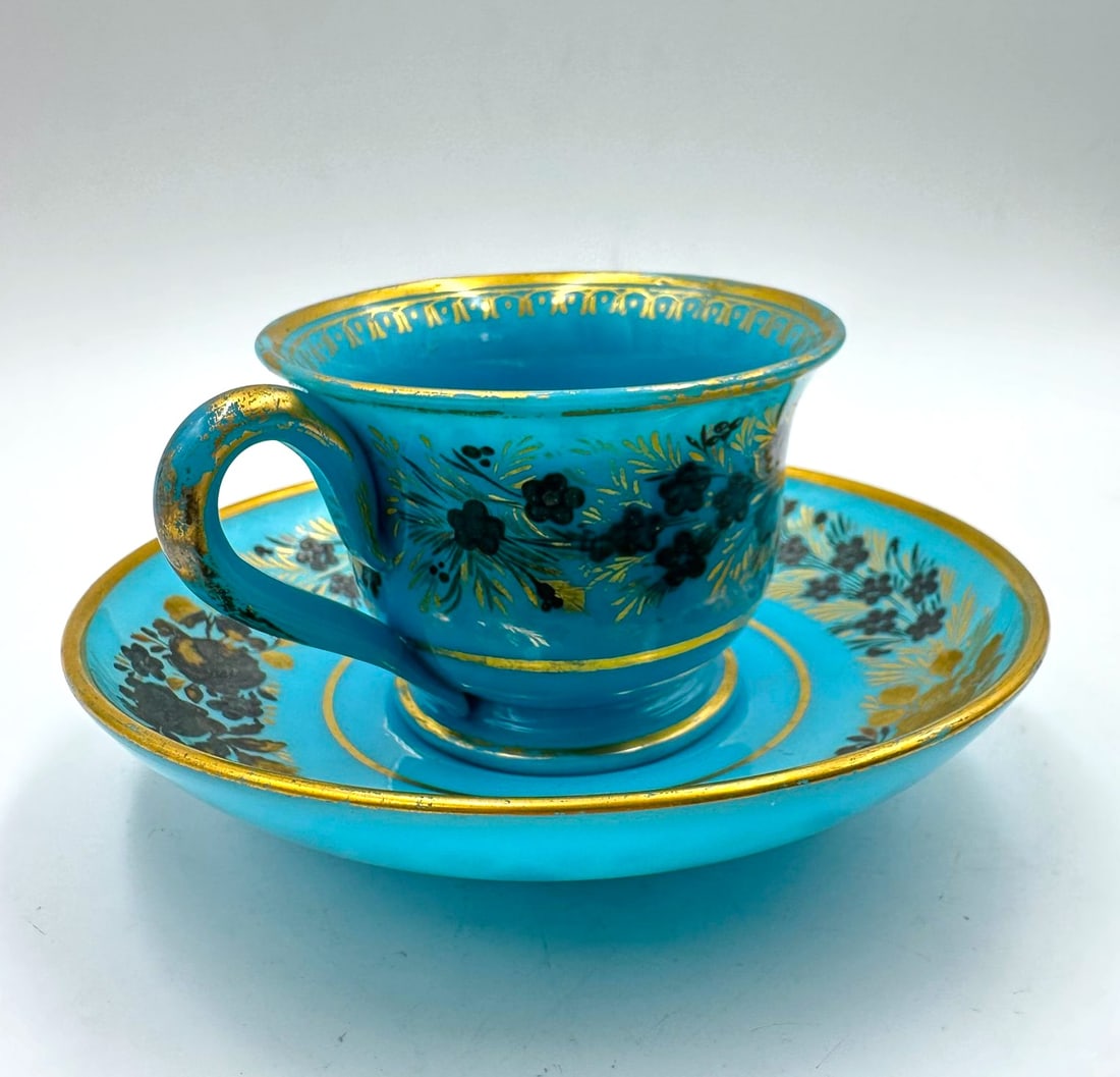 CUP AND SAUCER IN BLUE OPALINE WITH SILVER AND GOLD PAINTING, JEAN-BAPTISTE DESVIGNES, RESTORATION: Jean-Baptiste DESVIGNES (1786-1826)A turquoise-blue opaline glass cup and matching saucer, exquisitely hand-painted with garlands of forget-me-nots and roses using silver leaf, pigments, and gilded hi