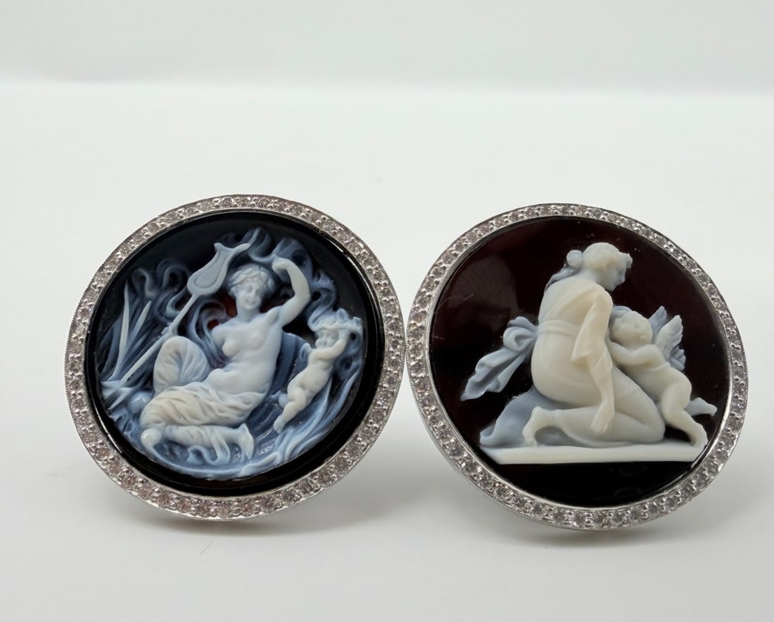 PAIR OF PLATINUM, AGATE CAMEO AND DIAMOND CLIP-ON EARRINGS: A fine pair of circular platinum (950/1000) clip-on earrings, each set with a round carved agate cameo depicting classical mythological scenes (one depicting a woman playing the lyre to a putto, the o