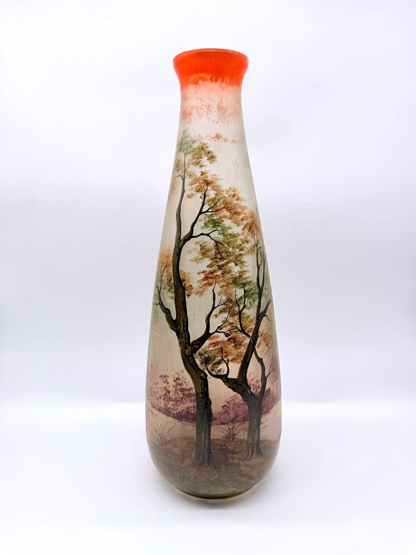 ART NOUVEAU LEUNE GLASS VASE WITH LANDSCAPE SCENE: Ovoid-shaped frosted glass vase with a tall tapering neck and vivid orange-tinted rim. The body is hand-painted in polychrome enamels featuring a detailed atmospheric autumnal forest landscape depicti
