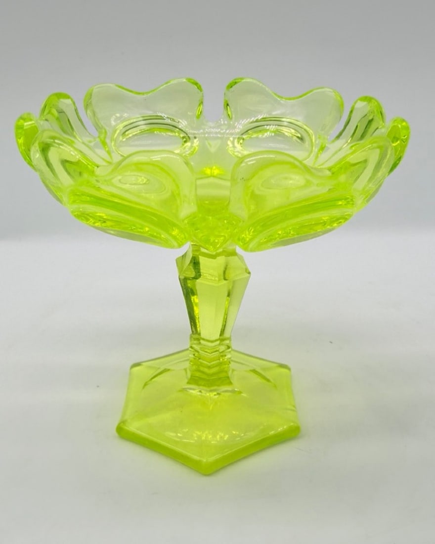 BOHEMIAN URANIUM GLASS FOOTED TAZZA: Uranium glass (Annagrün) tazza featuring a wide, scalloped rim with relief-molded oval motifs atop a faceted hexagonal baluster stem and a matching flat hexagonal foot base. The vibrant yellow-green 