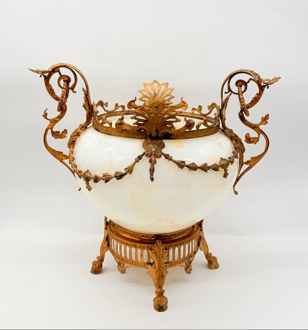 FRENCH OPALINE GLASS AND GILT-BRONZE CENTERPIECE CACHEPOT: Opaline glass centerpiece bowl with soft honey-yellow inclusions, mounted in elaborate gildedbronze (ormolu) fittings. The piece features dynamic scroll handles embellished with acanthus foliage, drap