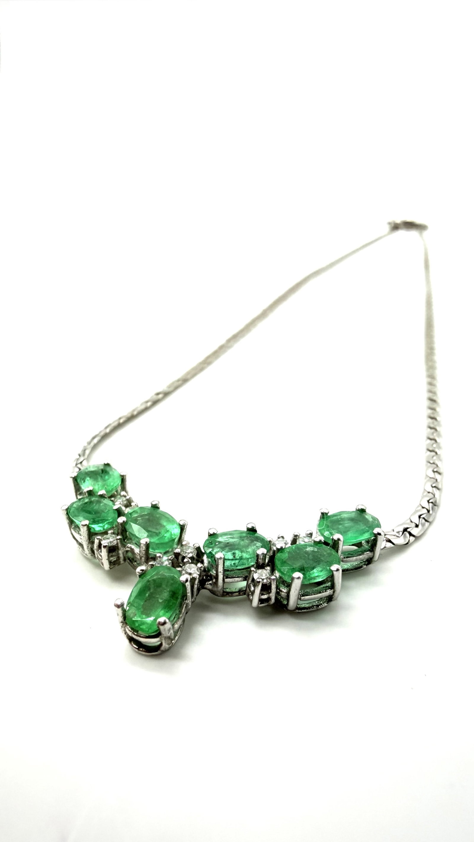14K white gold necklace set with seven faceted emeralds and nine diamonds: 14K white gold (585/1000) necklace set with seven faceted emeralds and nine diamonds.H_4 mm; L_6 mm (emerald dimensions)Very good condition.