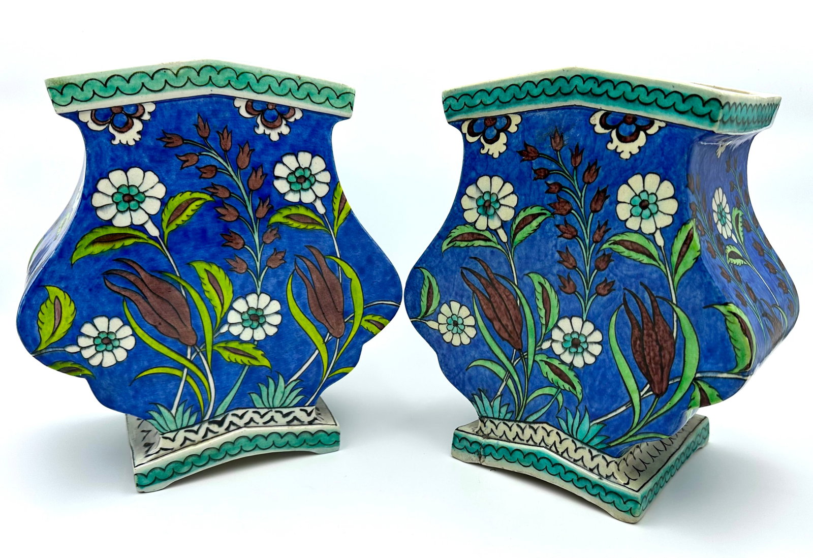 PAIR OF SAMSON IZNIK-STYLE CERAMIC VASES: A pair of baluster-form ceramic vases painted in the Iznik style against a cobalt blue background. The body is decorated with floral motifs, including tulips, hyacinths, and prunus blossoms, framed by
