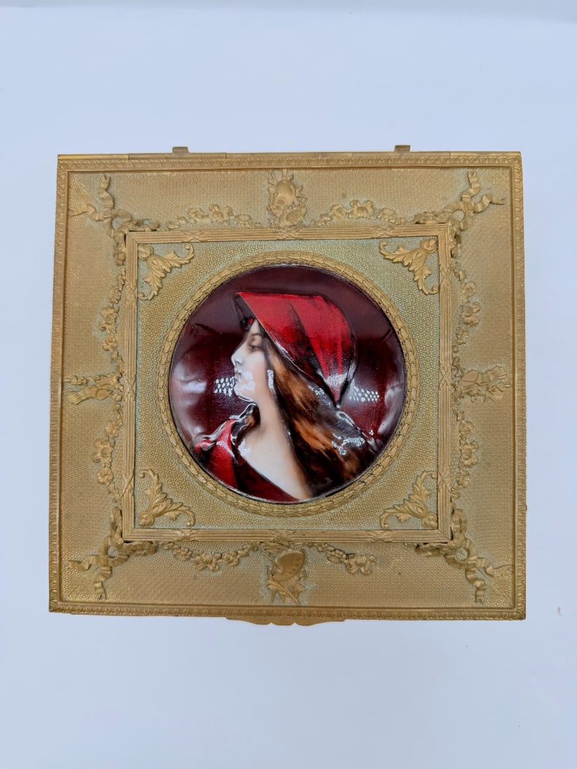 EMPIRE GILT BRONZE JEWELLERY CASKET WITH LIMOGES ENAMEL MINIATURE: An Empire gilt bronze (ormolu) jewellery casket, finely chased with ribbons, floral garlands, and acanthus leaf motifs. The hinged lid is inset with a Limoges enamel miniature depicting a portrait of 