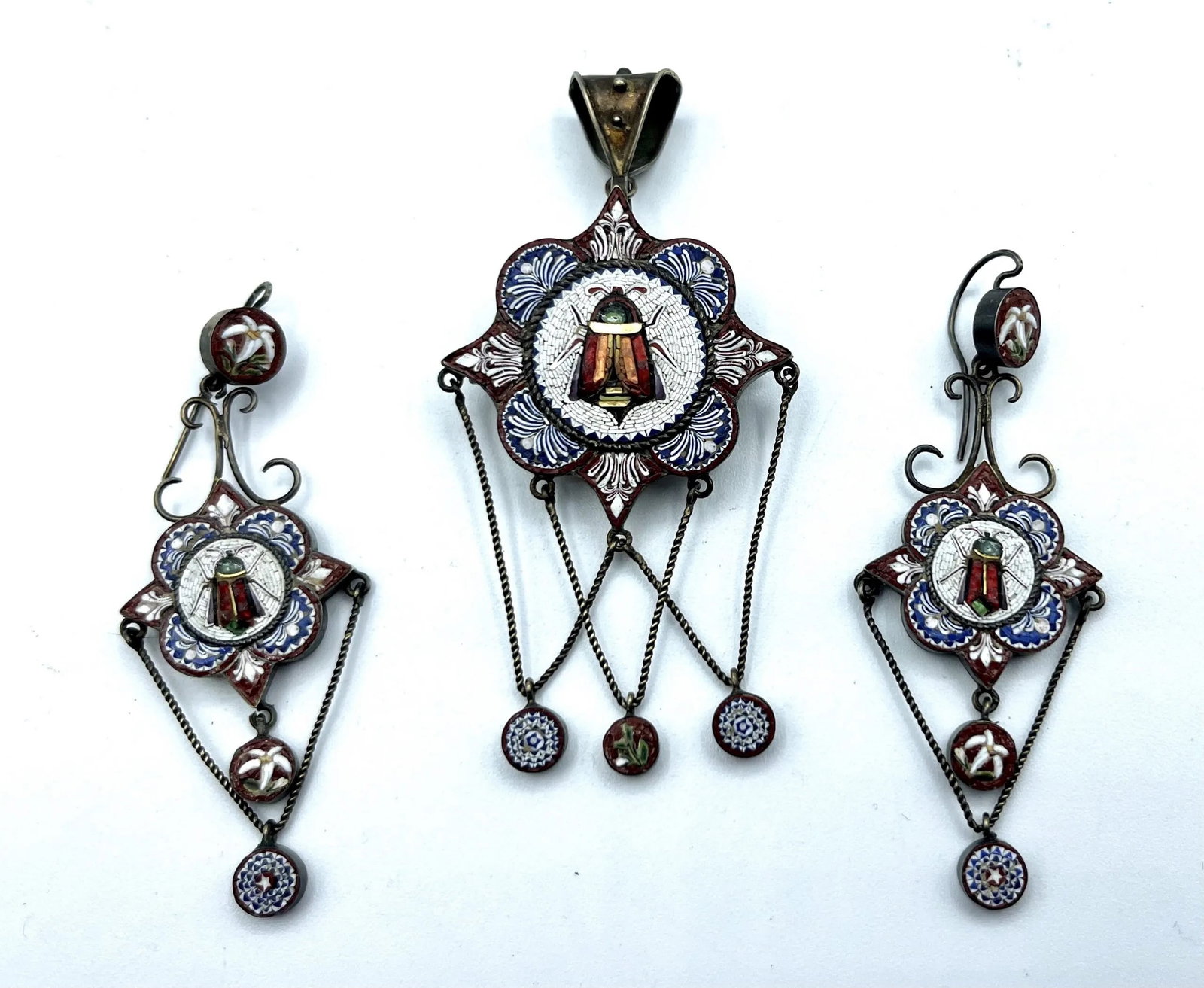 NAPOLEON III ITALIAN MICROMOSAIC PARURE, Italy, 19th Century (Grand Tour Souvenir) #: Italy, 19th Century (Grand Tour Souvenir)A 19th-century silver-tone metal jewelry set comprising a large brooch-pendant and a pair of drop earrings adorned with spun glass micromosaic (tesserae). The 