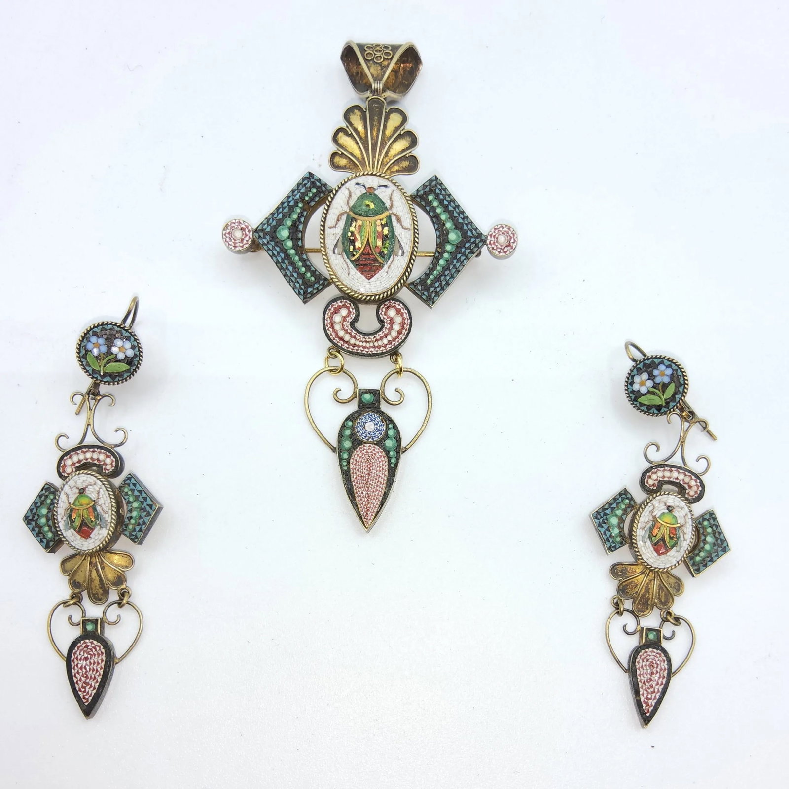 NAPOLEON III ITALIAN MICROMOSAIC PARURE, Italy, 19th Century (Grand Tour Souvenir): Italy, 19th Century (Grand Tour Souvenir)An architectural gilt-metal jewelry set comprising a large brooch-pendant and a pair of drop earrings decorated with spun glass micromosaic (tesserae). The cen