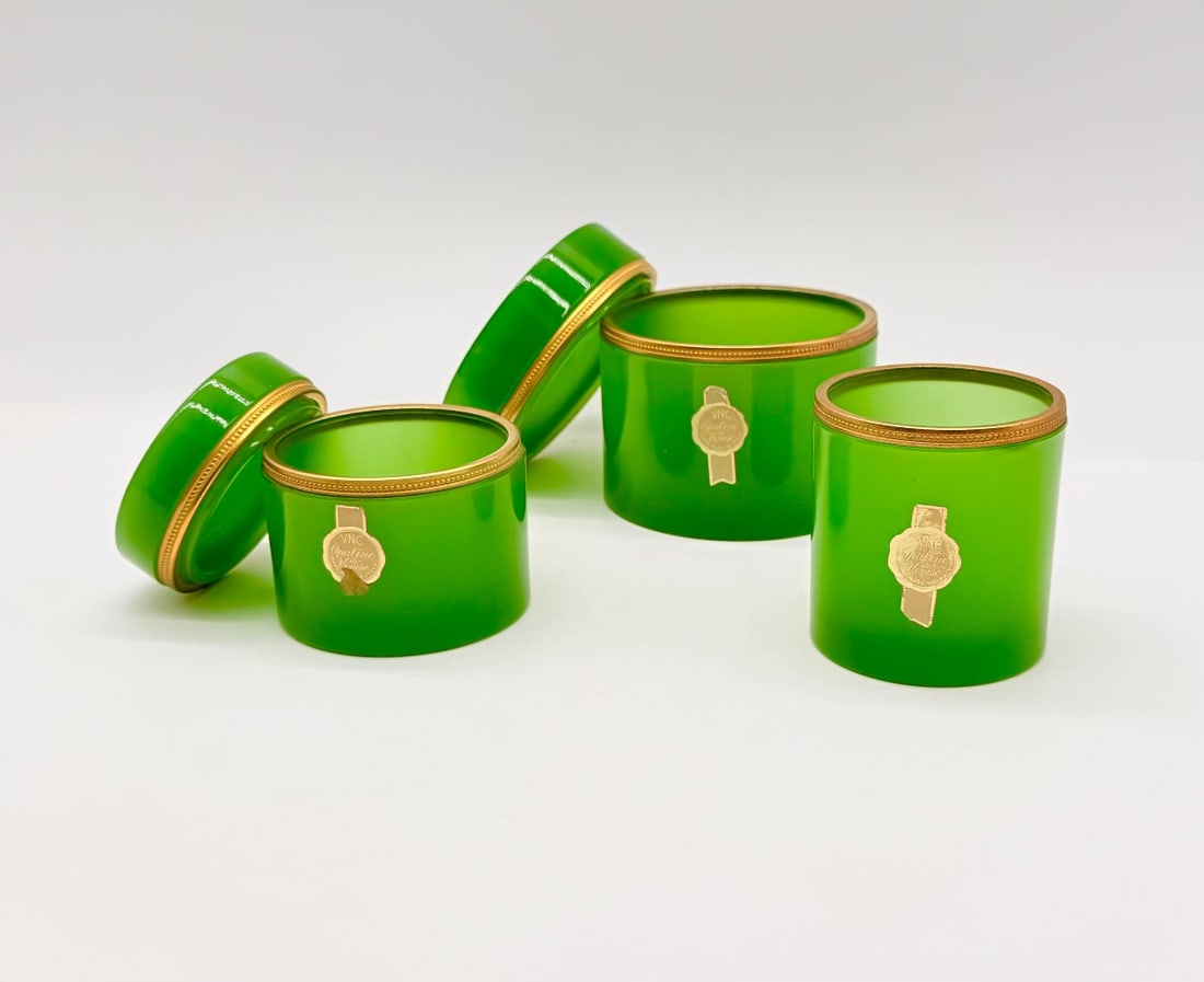 SET OF THREE ITALIAN VENETIAN GREEN OPALINE GLASS BOXES: A set of three cylindrical emerald green opaline glass vanity or trinket boxes, each fitted with beaded gilt metal rim mounts and matching lift-off lids. Each box retains its original foil maker's lab