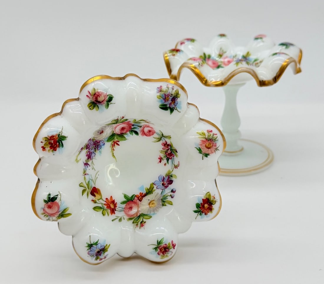 PAIR OF FRENCH WHITE OPALINE GLASS TAZZAS WITH FLORAL DECORATION: A fine pair of 19th-century French white opaline glass footed dishes (tazzas), featuring hand-painted polychrome enamel decoration. Each dish is designed with a scalloped, ruffled rim trimmed in gold 