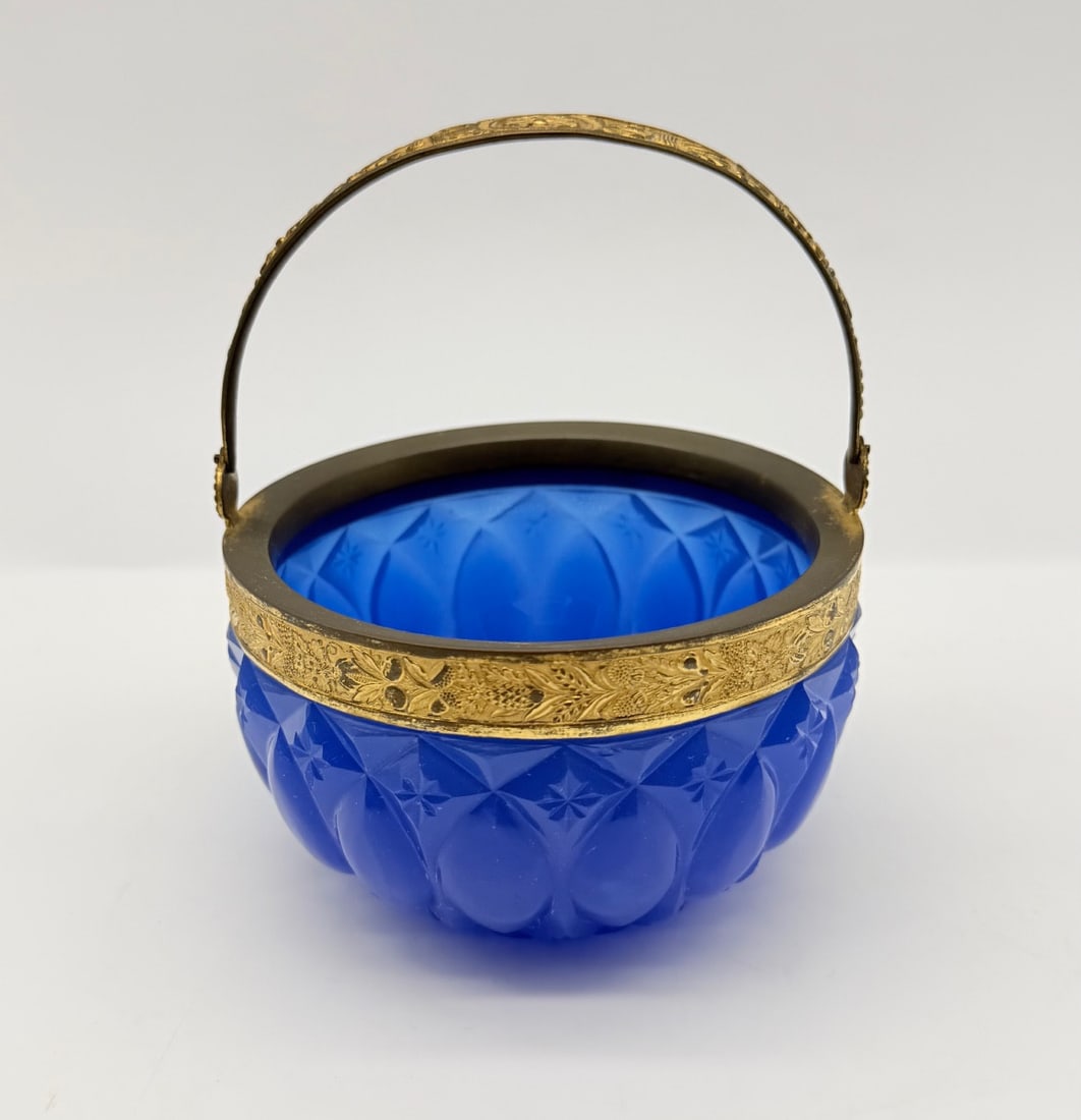 CHARLES X CUT COBALT BLUE OPALINE GLASS BASKET WITH GILT BRONZE MOUNT: A fine French lapis/cobalt blue opaline crystal basket (corbeille), deep-cut with flat facets and star-cut motifs. Fitted with an chased gilded bronze (ormolu) rim band engraved with floral scrolls, a