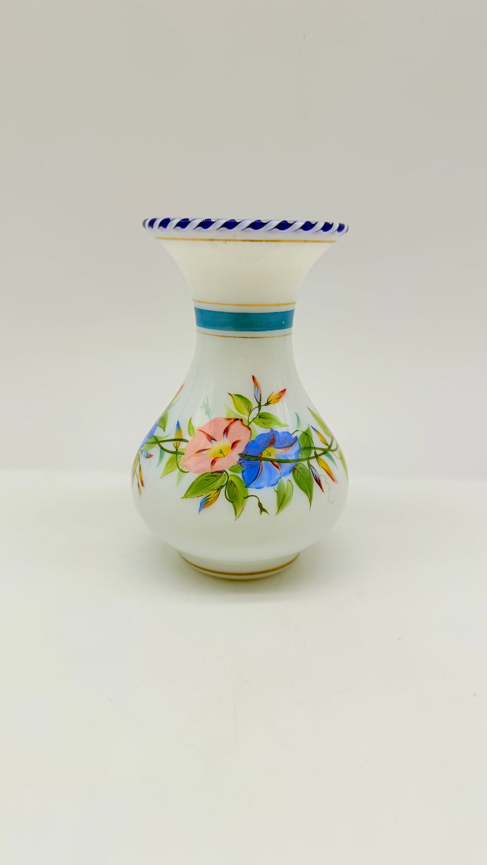 19TH-CENTURY FRENCH HAND-PAINTED OPALINE GLASS VASE ATTRIBUTED TO CLICHY: French white opaline glass vase featuring a baluster form with a flared neck. Hand-painted with colorful enamel morning glory floral motifs, framed by a blue neck band, gold striping, and a blue-and-w