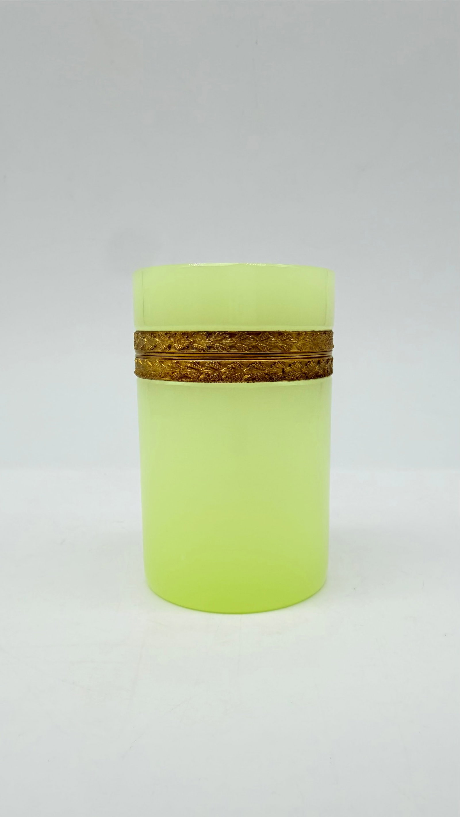 19TH-CENTURY OPALINE GLASS HINGED BOX: A 19th-century cylindrical hinged trinket box made of chartreuse/lemon-yellow opaline glass, fitted with a chased gilded bronze or brass mount.France. 19th century (Charles X / Napoleon III period).He
