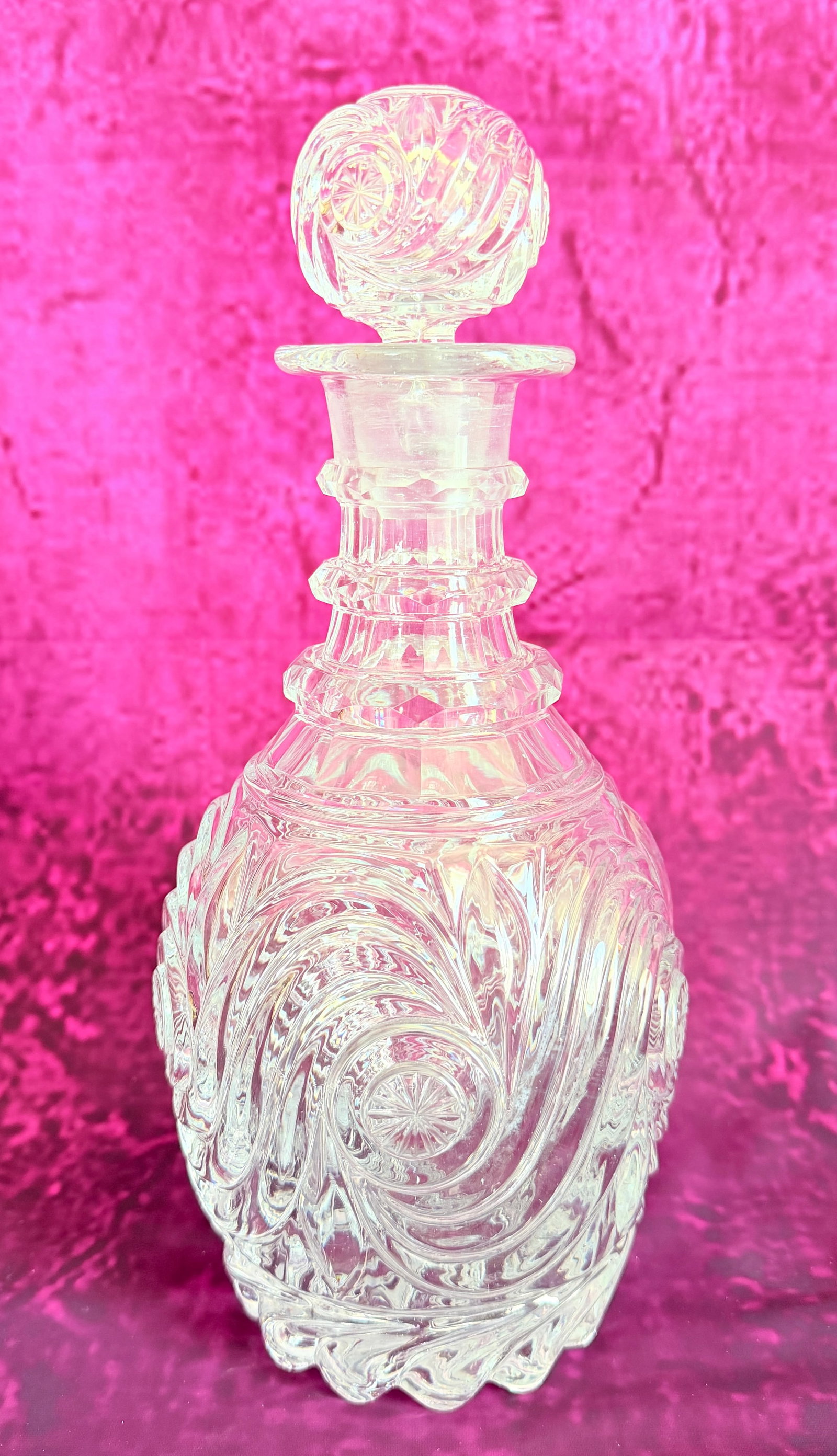 BACCARAT MOULDED CRYSTAL DECANTER WITH SWIRL DECORATION: An antique French clear crystal decanter by Baccarat, featuring a bulbous body and neck molded with swirling spiral ribs (côtes torses) and star motif medallions. Complete with its original matching 