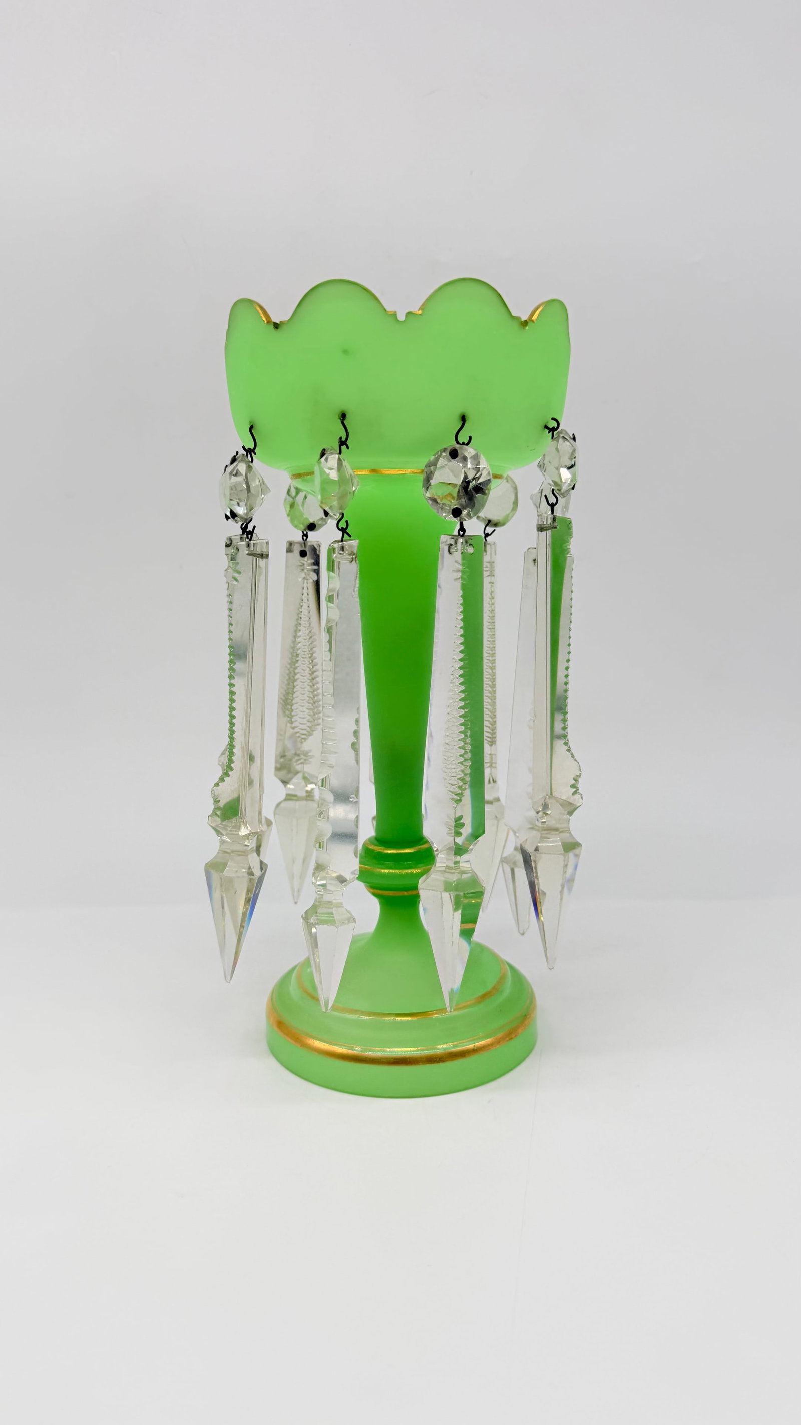 19TH-CENTURY GREEN OPALINE GLASS LUSTRE CANDLESTICK WITH CRYSTAL PRISMS: An antique 19th-century European mantle lustre or candlestick in apple-green opaque opaline glass with scalloped rim and gilded ring accents. Suspended around the rim are long cut-crystal prism drops 