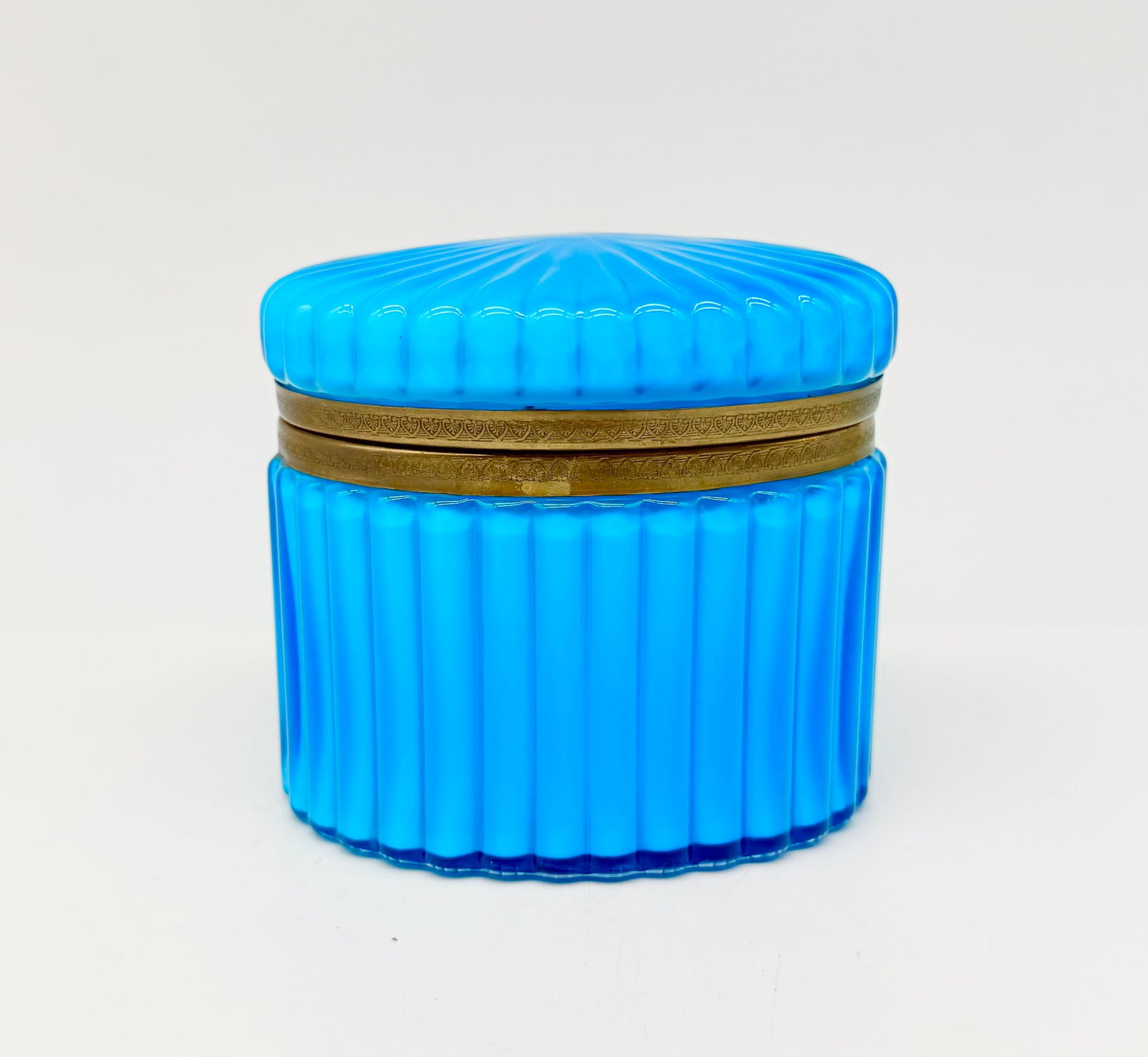 19TH-CENTURY FRENCH BLUE OPALINE GLASS HINGED BOX: Oval hinged box or trinket casket in vibrant turquoise-blue ribbed opaline glass (côtes creuses). Fitted with its original, finely engraved gilt brass hinged rim mount.France (attributed to Baccarat,