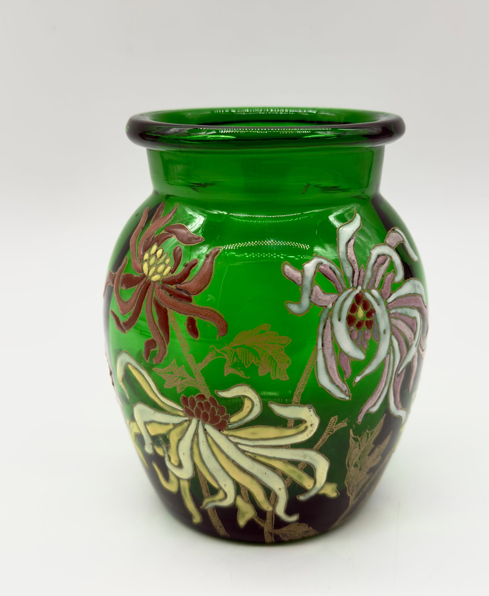 ART NOUVEAU ENAMELED GREEN GLASS VASE. LEGRAS-MONTGEOYE: Green glass vase decorated with hand-painted enamel floral motifs depicting chrysanthemums in shades of white, yellow, pink, and brown with gilded foliage accents. Features a baluster body with a thic