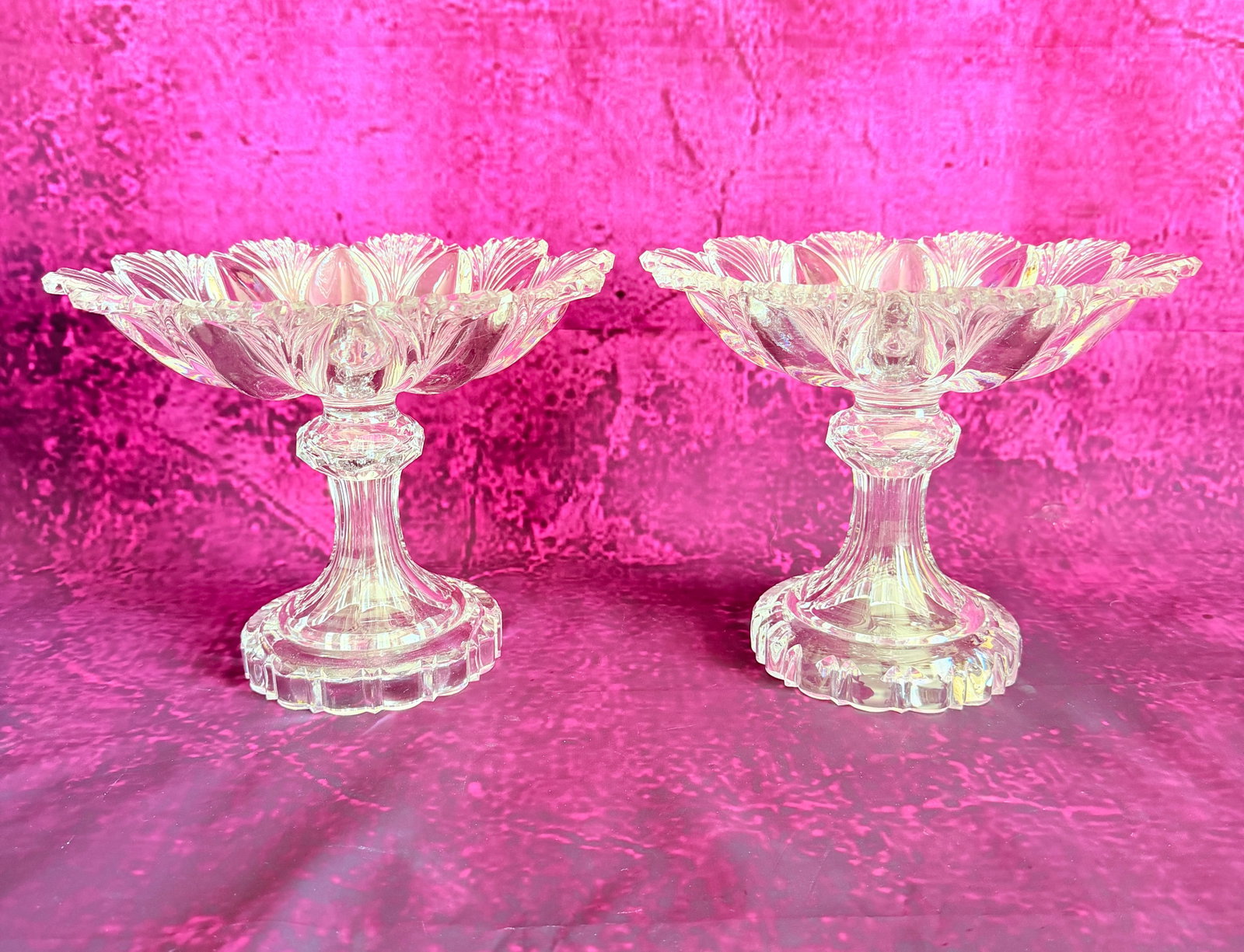 PAIR OF 19TH-CENTURY MOULDED CRYSTAL PEDESTAL BOWLS: A pair of 19th-century clear moulded glass or crystal pedestal bowls (compotiers). Features a flower-form dish with scalloped palmette petals radiating from the center, raised on a faceted knopped ste