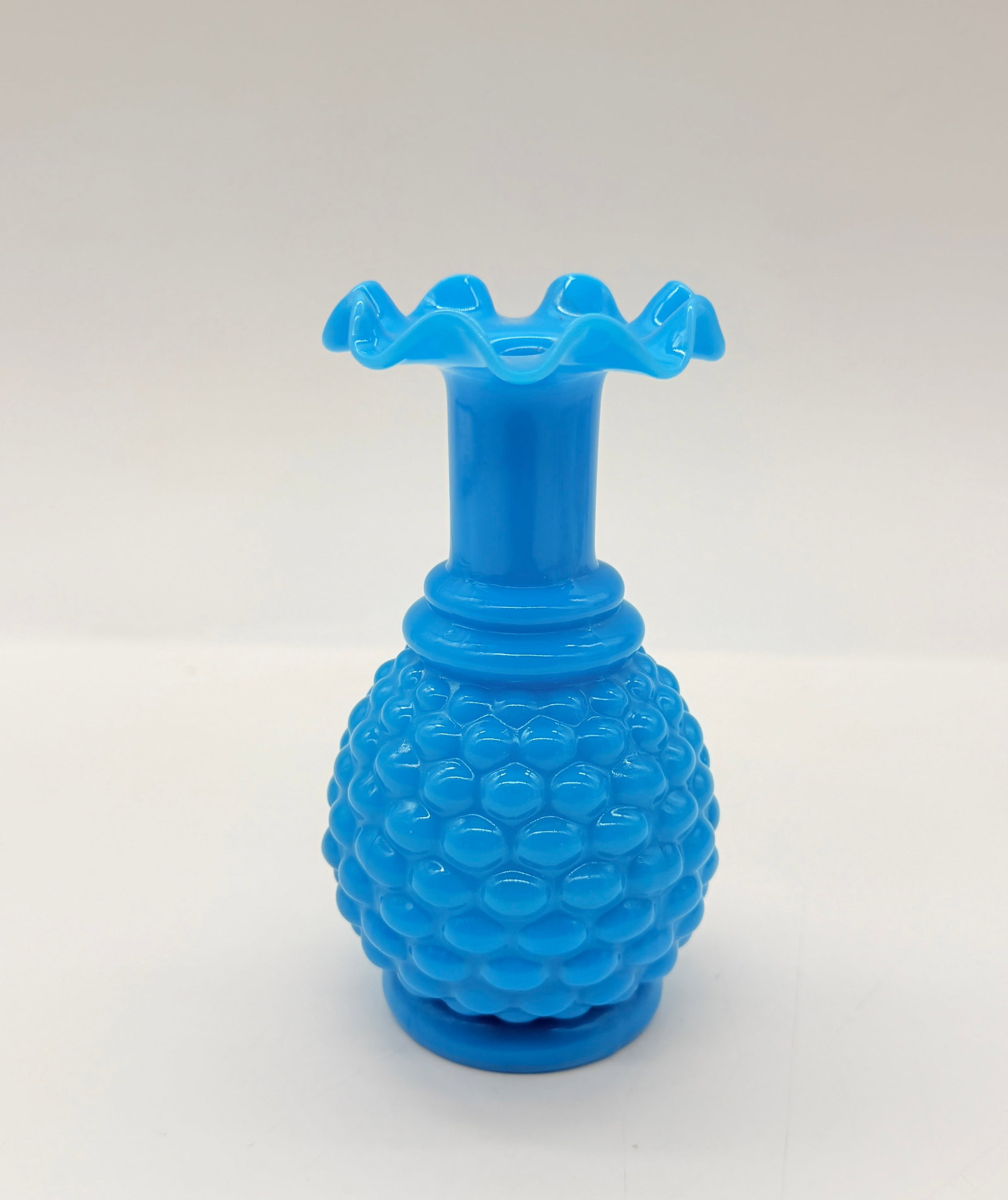 FRENCH OPALESCENT / MILK GLASS HOBNAIL VASE: A bright turquoise blue opaque glass vase featuring a crimped, ruffled rim, a straight neck, and a bulbous body decorated with a raised hobnail (pointes de diamant) pattern.France. Mid-20th century (c