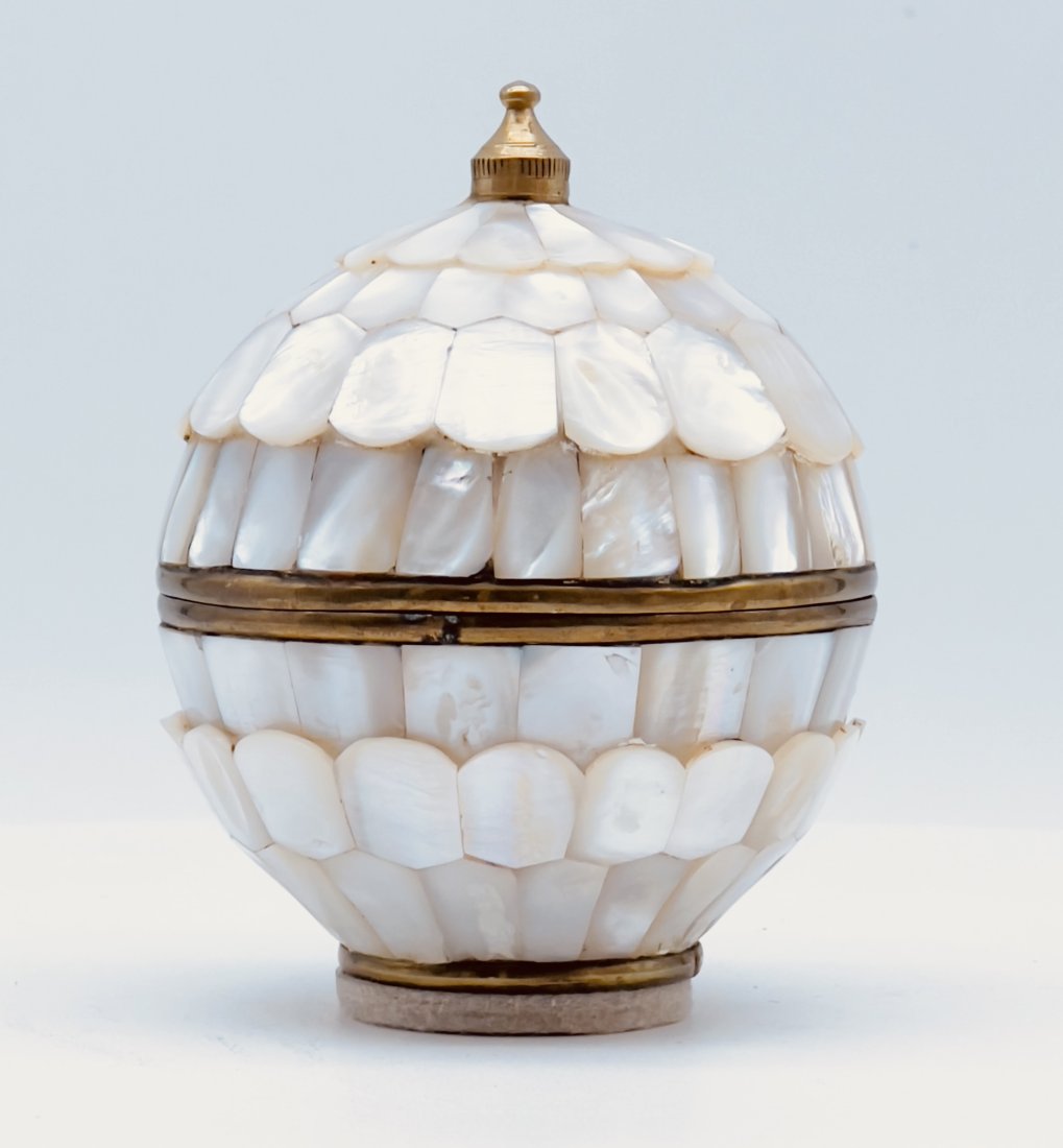 VINTAGE GILT METAL MOTHER OF PEARL COVERED TRINKET BOX AND COVER: A vintage, gilt metal tinket or gift box and cover, meticulously covered with hand cut mother of pearl. Size: Approx. 3 3/4 in. H x 3 1/4 in. W. PROVENANCE Coker Family Estate of South Carolina, found