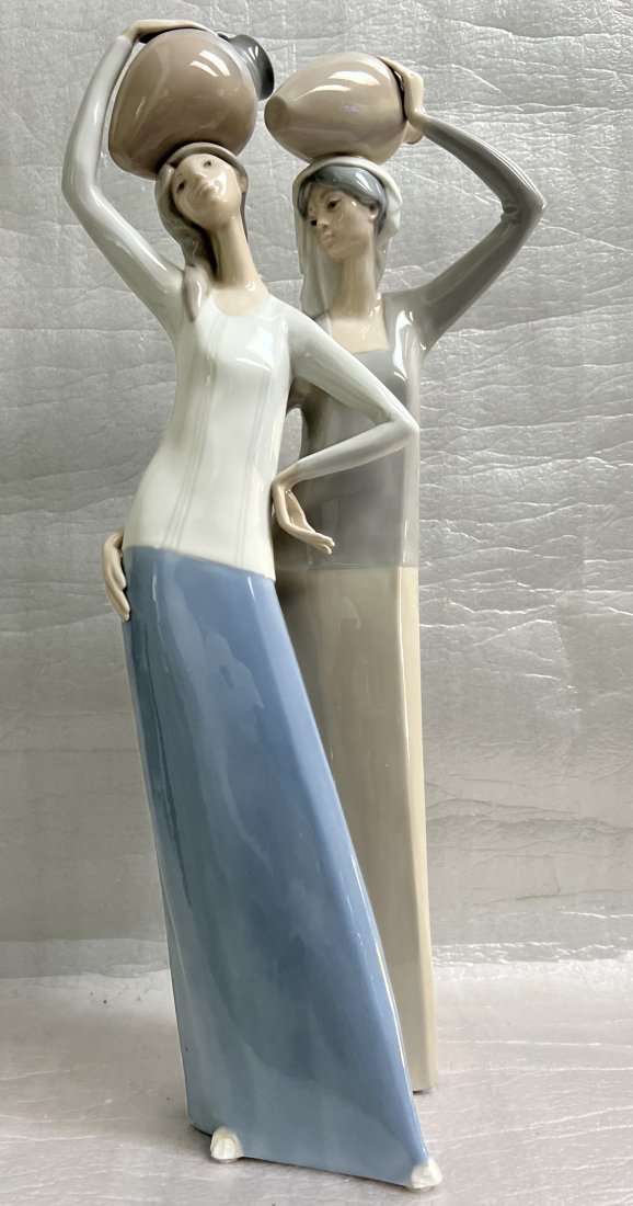 LLADRO TWO WOMEN CARRYING WATER JUGS ON THEIR HEADS , # 1014 FULGENCIO GARCIA: This exquisite ceramic sculpture depicts two women carrying water jugs on their heads. The intricate details and meticulous craftsmanship showcase the talent of the renowned artist, Fulgencio Garcia. 