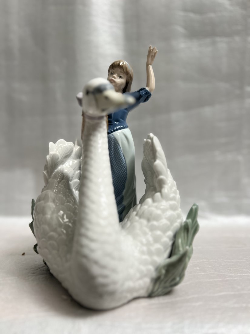 LLADRO PORCELAIN FIGURINE "THE SWAN AND THE PRINCESS" #5705 9"T 8"W 8" D: This exquisite Lladró porcelain figurine features the beautiful story of "THE SWAN AND THE PRINCESS". Measuring 9 inches in height and 8 inches in width, this large figurine depicts intricate details