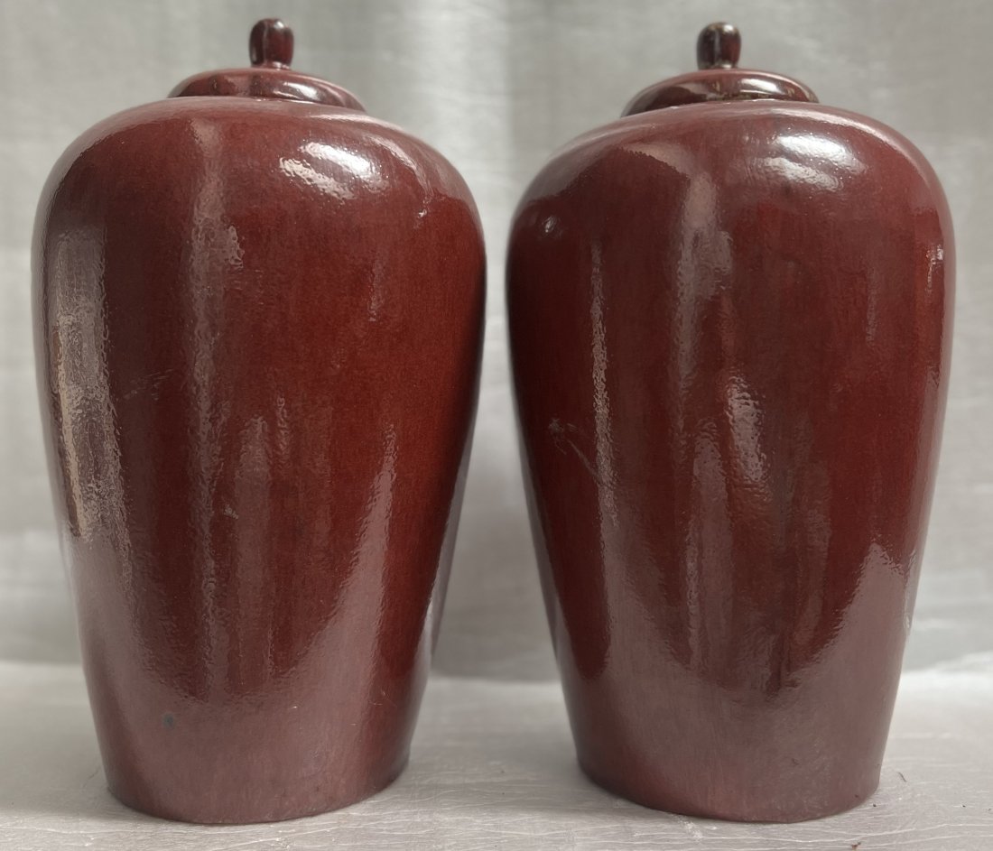 PAIR OF CHINESE SANG DE BOEUF FLAME GLAZE GINGER JARS W LIDS 14T: Add an exotic touch to your collection with this stunning pair of Chinese Sang de Boeuf Flame Glaze Ginger Jars with lids. These jars were crafted in China, showcasing the beauty of Chinese culture. T